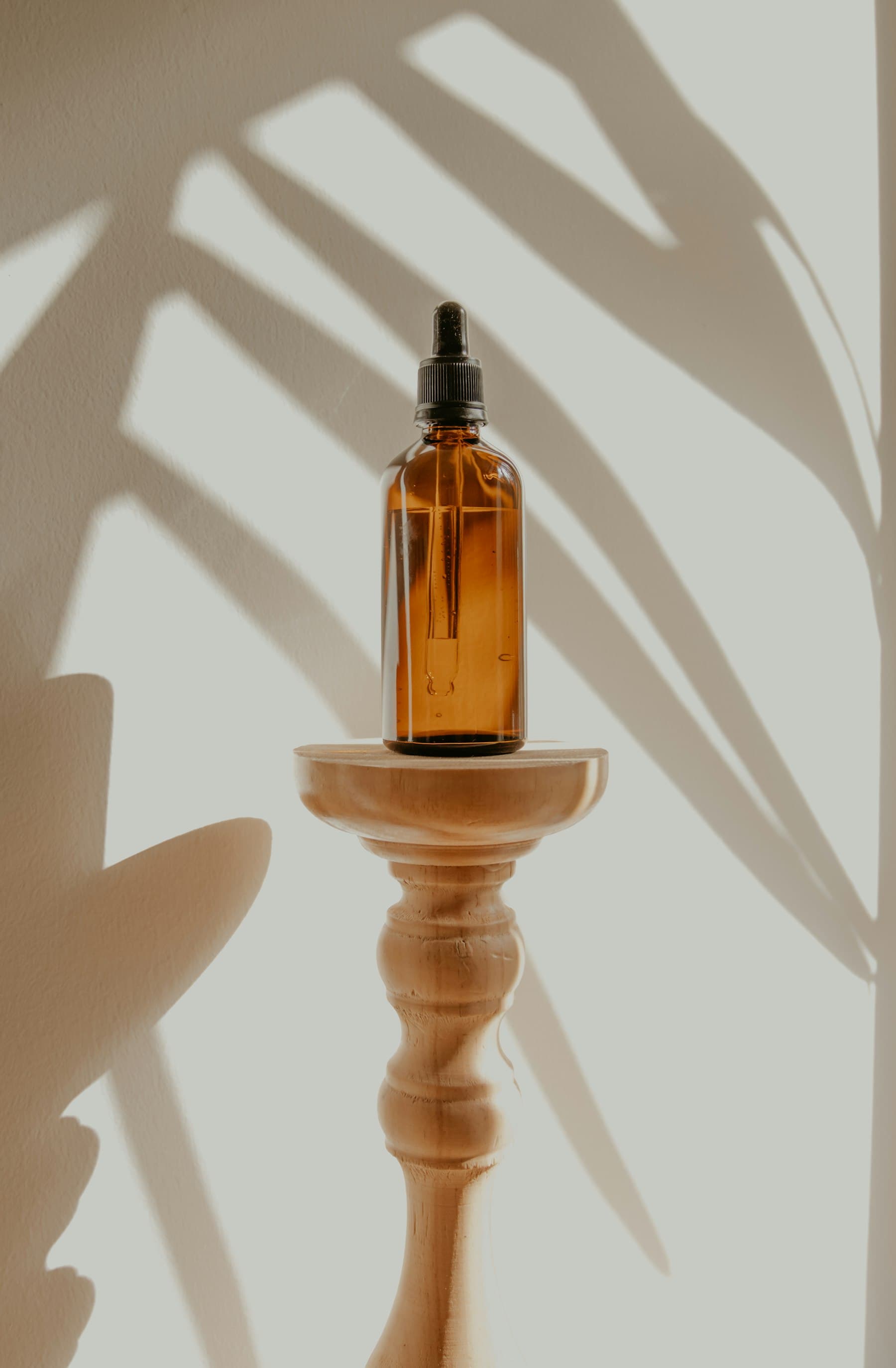 Amber dropper bottle on a wooden stand